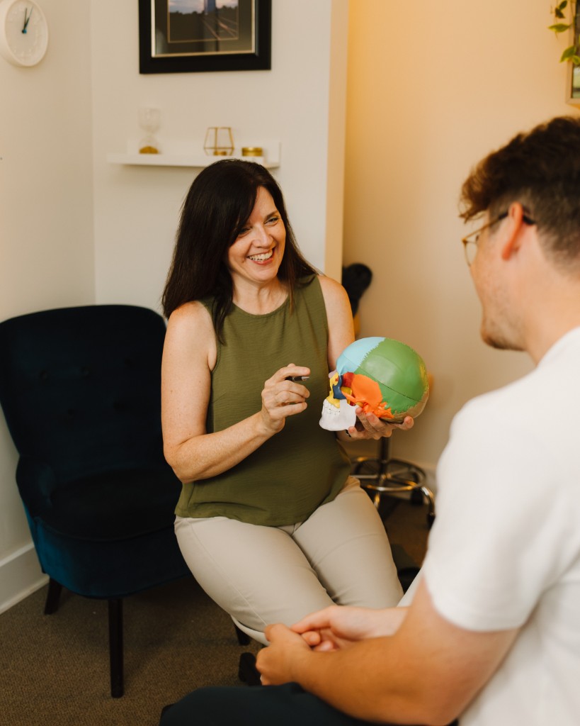 Elizabeth explaining craniosacral work with an anatomical skull model